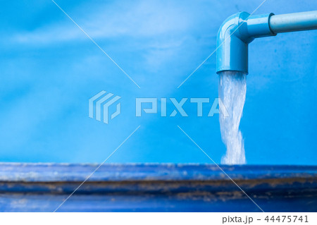 Blue pvc pipe with flowing water in bucket 44475741