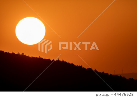 Big sun circle at dusk over mountains with orange sky 44476928