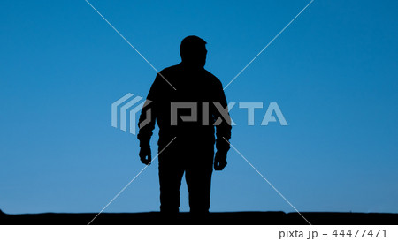 Silhouette of man stand on street, isolated sky. Silhouette of man stand on street, isolated sky. 44477471