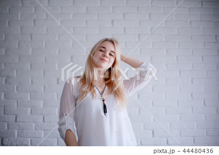 cute blond young adult / portrait of an adult beautiful girl model with blond hair in a happy image 44480436