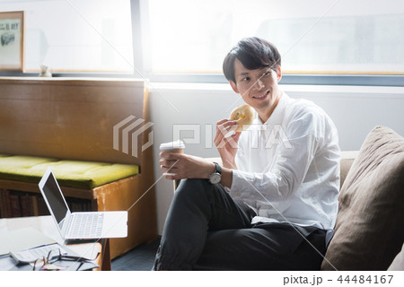 軽食をとりながら仕事をするビジネスマン 軽食をとりながら仕事をするビジネスマン 44484167