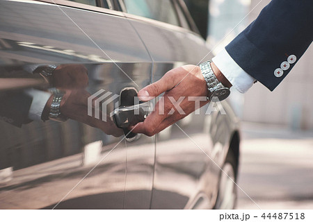 Hand on handle. Close-up of man hand opening a car door. Hand on handle. Close-up of man hand opening a car door. 44487518