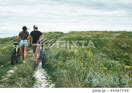 Couple cycling, man and woman, relationships. Rear view 44487549