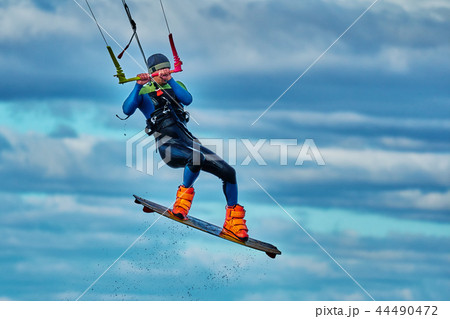 A male kiter jumps over a large lake. Close-up. A male kiter jumps over a large lake. Close-up. 44490472