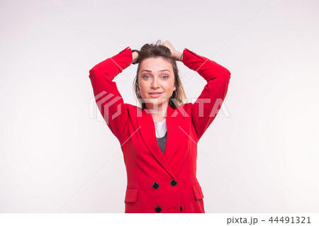 Surprised freckled young woman wearing red suit on white background Surprised freckled young woman wearing red suit on white background 44491321