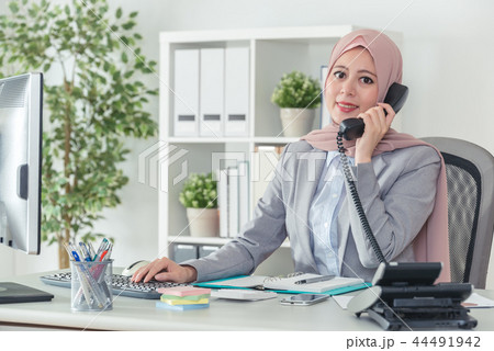 Muslim operator in office suit answering the phone call Muslim operator in office suit answering the phone call 44491942
