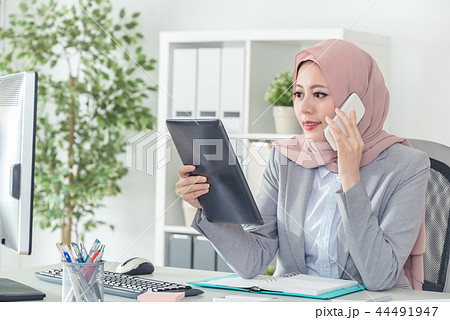 Muslim employee contact customers and hold tablet Muslim employee contact customers and hold tablet 44491947