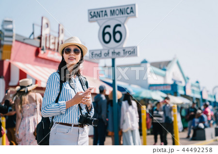 tourist standing next to the sign of Santa Monica 44492258