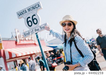 an elegant female tourist pointing to the sign 44492259