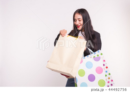 Portrait of young happy brunette woman with shopping bags on white background with copy space 44492756