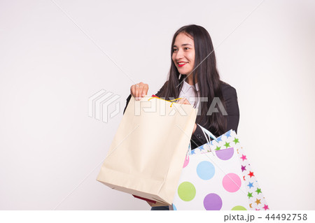 Happy asian woman with red lips holding shopping bags on white background with copy space 44492758