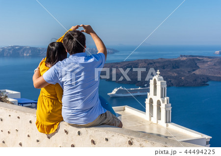 Couple enjoying the view of Santorini Couple enjoying the view of Santorini 44494225