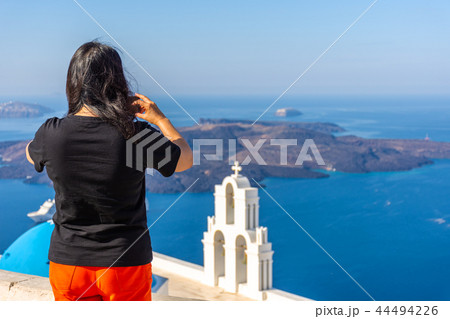 Tourist enjoying the view of Santorini Tourist enjoying the view of Santorini 44494226