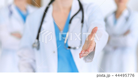Group of medicine doctors offering helping hand for shaking hand or saving life closeup. Partnershi Group of medicine doctors offering helping hand for shaking hand or saving life closeup. Partnershi 44495776