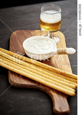 golden beer and delicious salty snacks on an old black wooden table 44496366