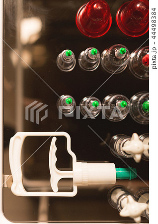 Medical set of glass jars and piston vacuum massage in a dark room. Top view Medical set of glass jars and piston vacuum massage in a dark room. Top view 44498384
