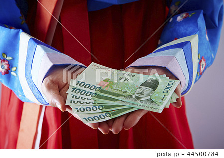 韓国通貨ウォン紙幣を持つチマチョゴリの女性 44500784
