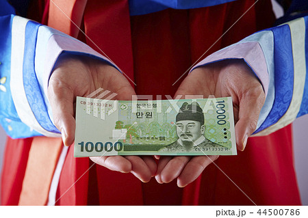韓国通貨ウォン紙幣を持つチマチョゴリの女性 44500786