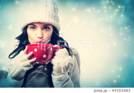 Woman in winter clothes drinking coffee 44503065