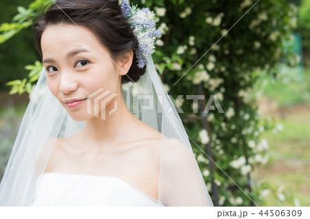 バラの前で微笑むウエディングドレスの女性 バラの前で微笑むウエディングドレスの女性 44506309