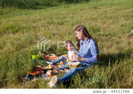 mother and young son eat at a picnic in the forest 44511760