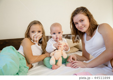 three girls play sisters in the bedroom on the bed in the morning three girls play sisters in the bedroom on the bed in the morning 44511899