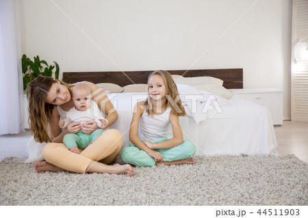 three girls play sisters in the bedroom on the bed in the morning 44511903