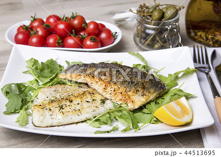 Grilled seabass fillet with arugula, lemon Grilled seabass fillet with arugula, lemon 44513695