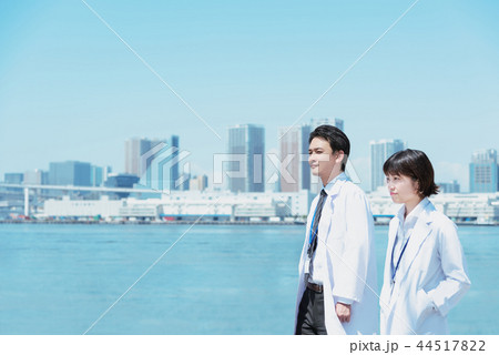 会話しながら海辺を歩く白衣の男女 44517822