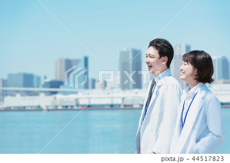 会話しながら海辺を歩く白衣の男女 会話しながら海辺を歩く白衣の男女 44517823