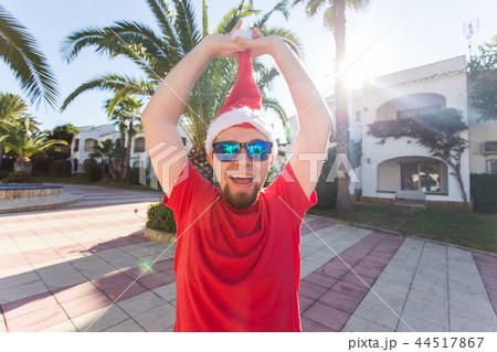 Christmas, holidays, humor, people concept - man take off the christmas hat from his head 44517867