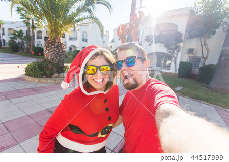 Young couple wearing christmas costumes making selfie photo outdoors 44517999