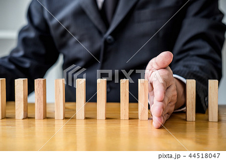 Wooden game strategy, Businessman hand stopping falling wooden d 44518047
