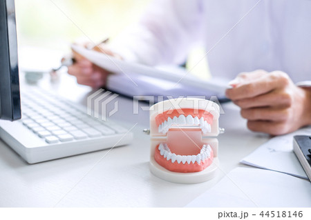 Male doctor or dentist writing report working with tooth x-ray f 44518146
