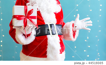 Santa holding a Christmas gift Santa holding a Christmas gift 44519305