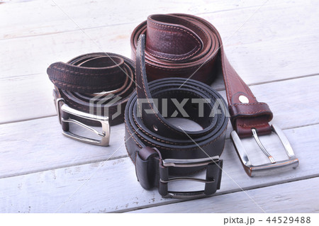 Gadgets and accessories for men on light wooden background. Fashionable men s belt, wallet, lighter 44529488