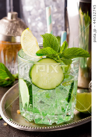 Close up retro glass jars of lemonade with cucumber and mint on wooden table Close up retro glass jars of lemonade with cucumber and mint on wooden table 44532745