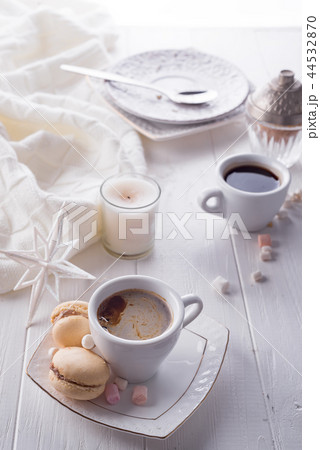 Tasty sweet macarons and coffee cup on white wooden background. Cristmas concept lazy morning, warm Tasty sweet macarons and coffee cup on white wooden background. Cristmas concept lazy morning, warm 44532870