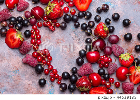Heart shape assorted berry fruits on stone background. Flat lay Heart shape assorted berry fruits on stone background. Flat lay 44539135