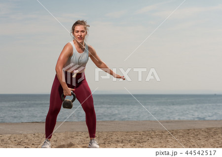 Young sporty woman training with kettle bell 44542517