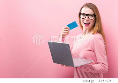 Young woman holding a laptop and a credit card Young woman holding a laptop and a credit card 44542911