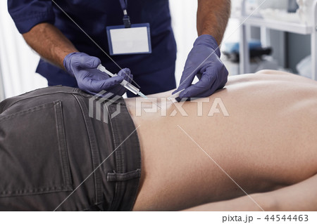 Doctor is making an injection in back of man Doctor is making an injection in back of man 44544463