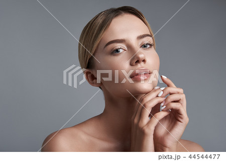 Peaceful woman having her hands near the face and looking at you 44544477