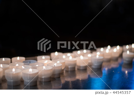 Close-up detail of multiple short candles lighting up a church. Travel and religion concept. Close-up detail of multiple short candles lighting up a church. Travel and religion concept. 44545357
