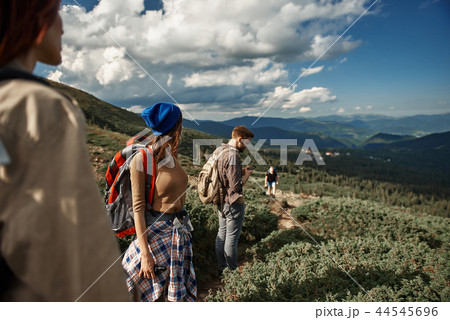 Four young hikers are travelling in mountains Four young hikers are travelling in mountains 44545696