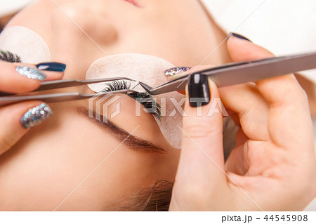 Eyelash Extension Procedure. Woman Eye with Long Eyelashes. Close up, selective focus. 44545908