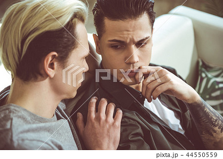 Loving boyfriend touching shoulder of sad young man Loving boyfriend touching shoulder of sad young man 44550559