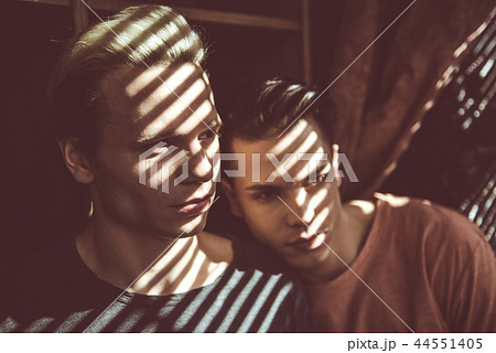 Young gay couple standing close to each other at home 44551405