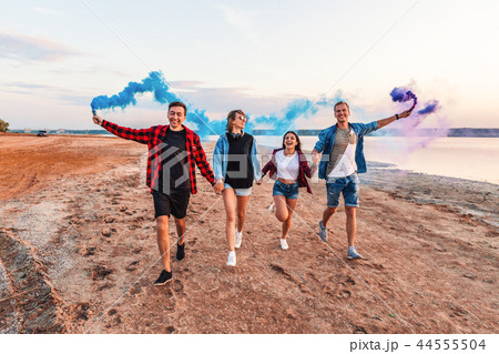 young friends running with hand flare or fusee young friends running with hand flare or fusee 44555504