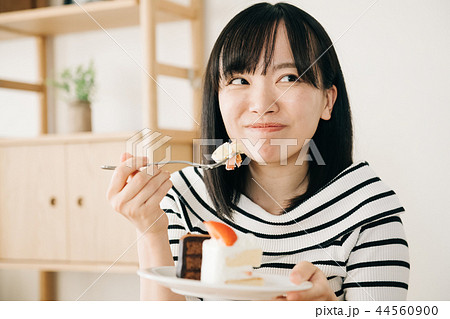 ショートケーキを食べる若い日本人女性の写真素材